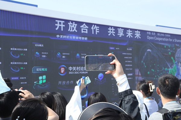 1.记者们集聚北京·海淀中关村国家自主创新示范区展示中心门,用手机记录“开放合作·共享未来”永久主题.JPG